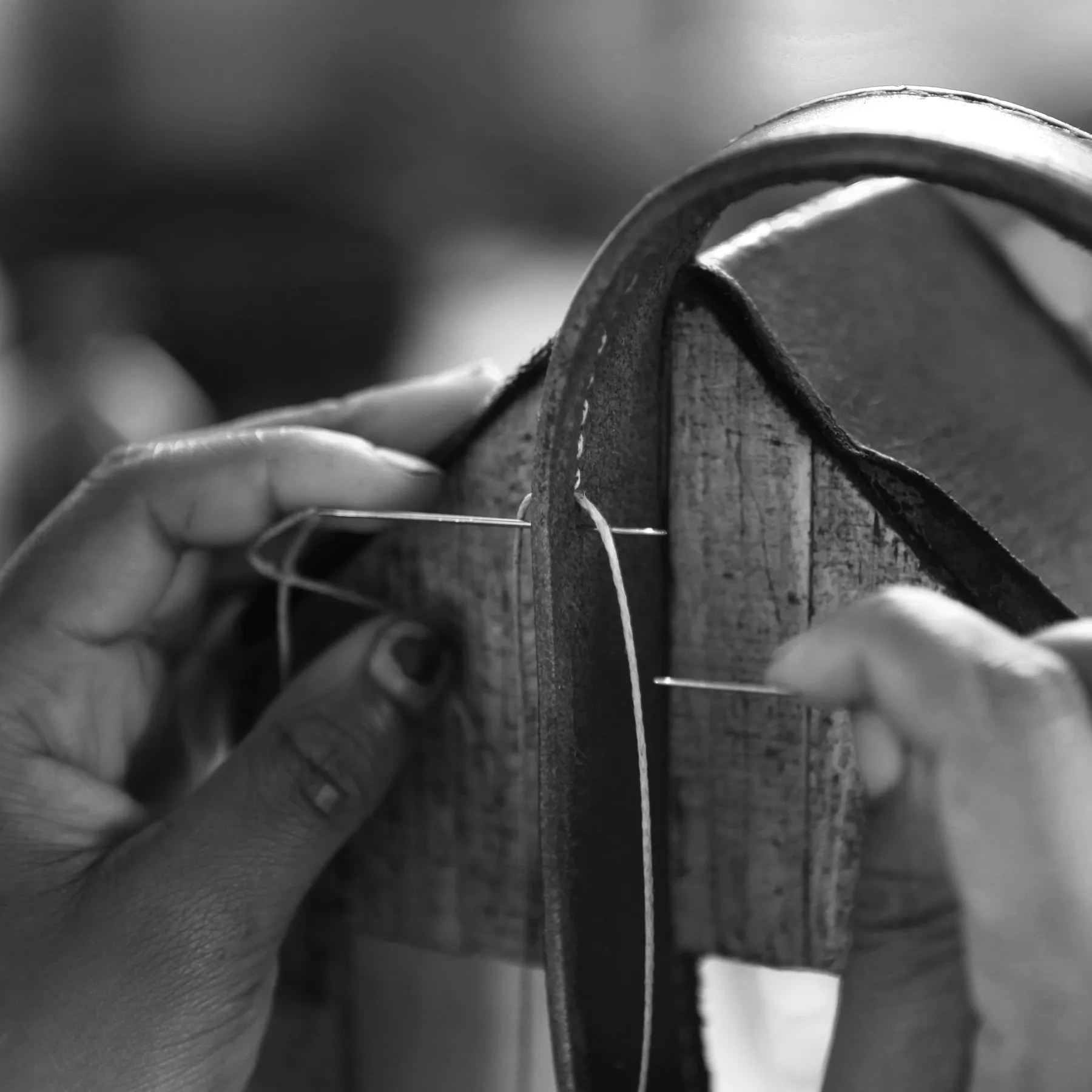 Close-up of stitching leather by hand